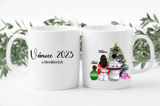 Rodinný vánoční hrneček rodiče s malým dítětem u vánočního stromečku. Vánoce 2023.